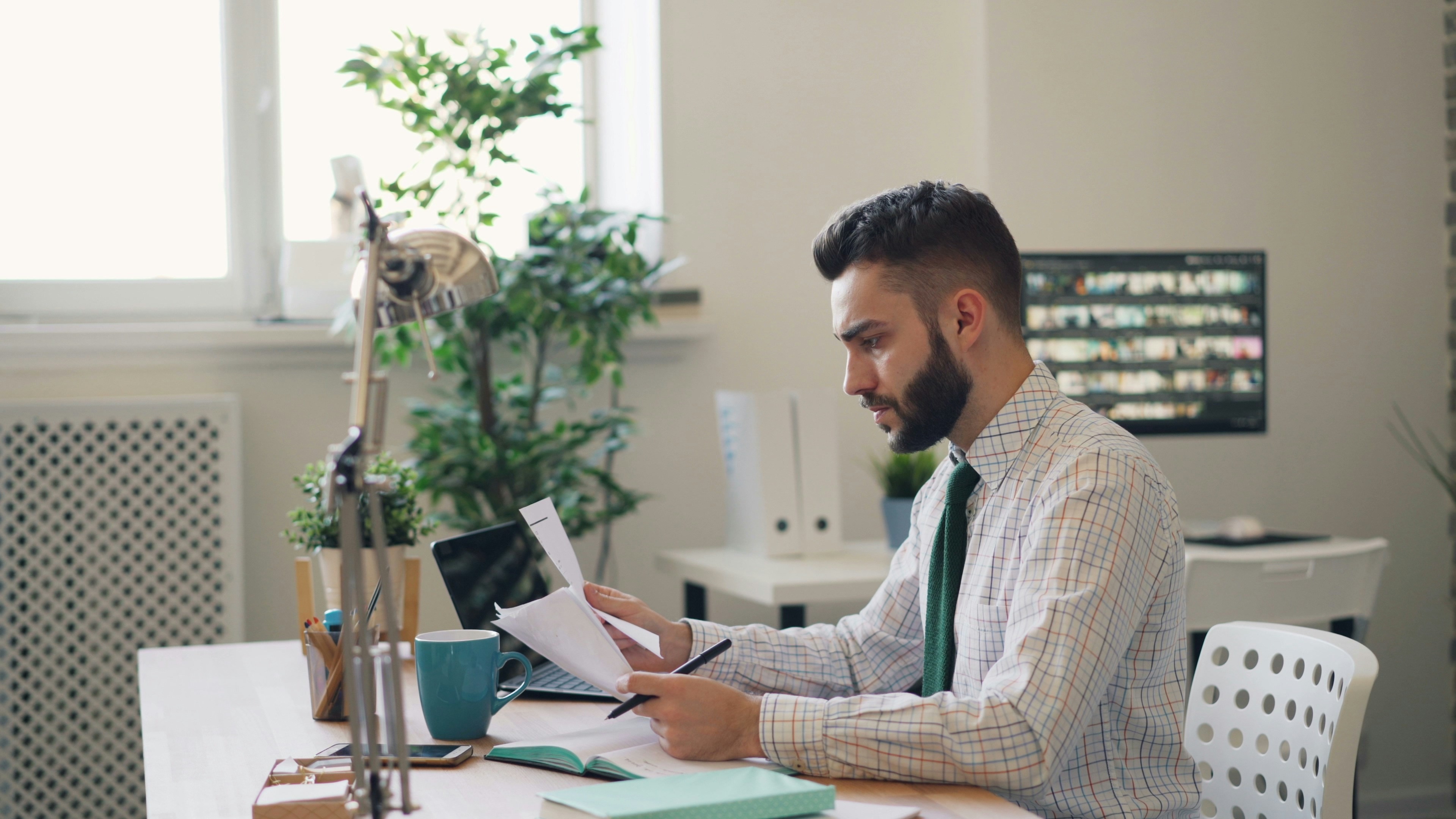 Man in suit working at a desk looking at papers