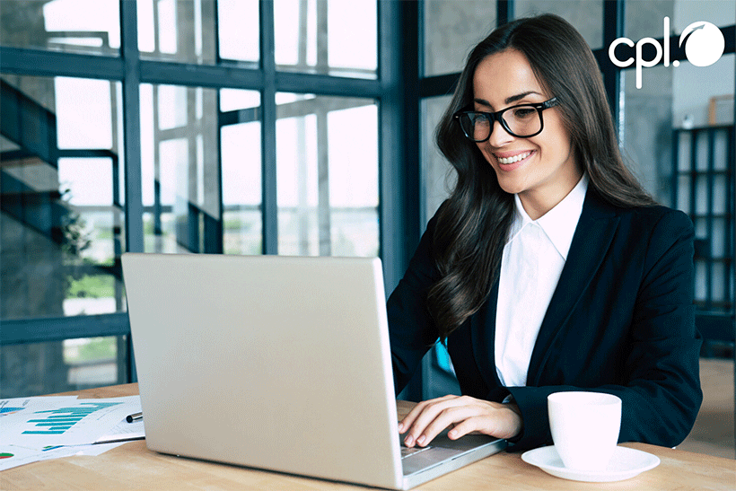 Female financial services worker on laptop in office. 