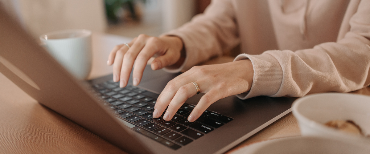 Woman typing on a laptop keyboard