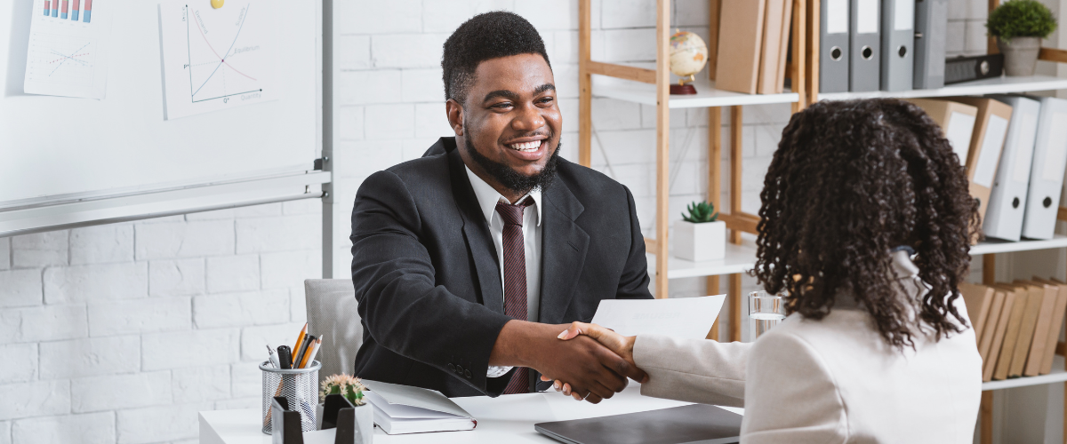 Man and Woman in a job interview shaking hands.